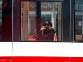 A man, wearing a mask, rides the street car through the Chinatown district of downtown Toronto, where so far, three patients with novel coronavirus were reported in Canada Jan. 28, 2020.