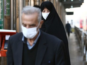 Iranian people wear protective masks to prevent contracting a coronavirus, in Tehran, Iran February 29, 2020.
