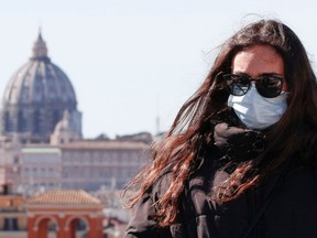 A woman wears a protective mask in downtown Rome, Italy, February 28, 2020.