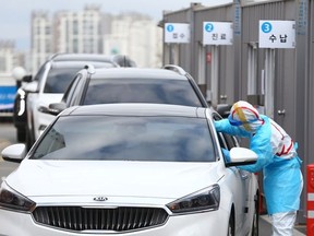 A driver gets a coronavirus test at a drive-through clinic at a hospital in Daegu, South Korea, February 27, 2020.