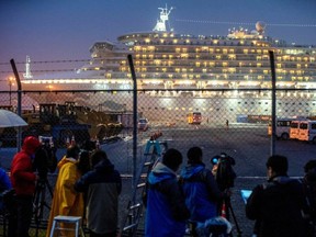 A bus arrives near the cruise ship Diamond Princess, where dozens of passengers were tested positive for coronavirus, at Daikoku Pier Cruise Terminal in Yokohama, south of Tokyo, Japan.