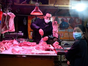 A vendor wearing a protective mask prepares an order at a market in Shanghai on February 11, 2020. (NOEL CELIS/AFP via Getty Images)