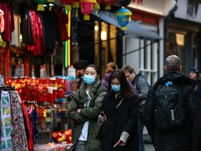 In this Feb. 2, 2020, file photo, women wear face masks in Chinatown on  in London, England.