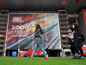 People walk past a poster for the Chinese Grand Prix last year in Shanghai. (REUTERS/Aly Song/File Photo)
