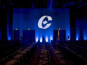 A man is silhouetted walking past a Conservative Party logo before the opening of the Party's national convention in Halifax on Thursday, Aug. 23, 2018.