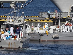 Workers in protective gear are seen on the Japan Coast Guard boats in Yokohama on Feb. 5, 2020 bringing patients from the Diamond Princess cruise ship.