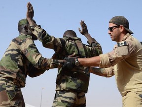 A Canadian Special Operations Regiment instructor teaches soldiers from the Niger Army how to properly search a detainee in Agadez, Niger, Feb. 24, 2014 during that year’s Flintlock exercise.