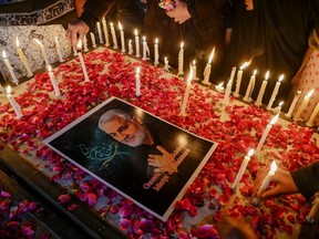 Shiite Muslims place candles around a picture of slain top Iranian general Qasem Soleimani to pay him tribute during a candle light vigil in Islamabad January 8, 2020.