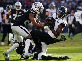 Chris Conley of the Jacksonville Jaguars is tackled by Trayvon Mullen of the Oakland Raiders after a catch during the second half at RingCentral Coliseum on December 15, 2019 in Oakland, California. (Daniel Shirey/Getty Images)