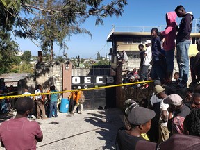 People stand outside the Orphanage of the Church of Bible Understanding where a fire broke out the previous night in Port-au-Prince, Haiti, Friday, Feb. 14, 2020. (AP Photo/Dieu Nalio Chery)