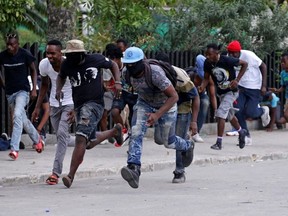 Protesters run for cover during a shooting in Champ de Mars, Port-au-Prince, Haiti February 23, 2020.