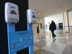 Hand sanitizers hang on the wall with a sign about COVID-19, also known as coronavirus from the UN World Health Organization (WHO) at the United Nations Headquarters on February 27, 2020. (TIMOTHY A. CLARY/AFP via Getty Images)