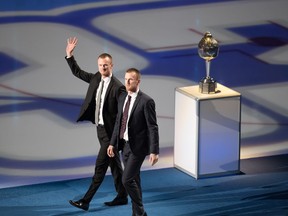 Former Canucks players Henrik Sedin and his twin brother Daniel Sedin, and their families watch as their numbers are raised to the rafters during a jersey retirement ceremony before an NHL game in Vancouver, on Wednesday, Feb. 12, 2020.