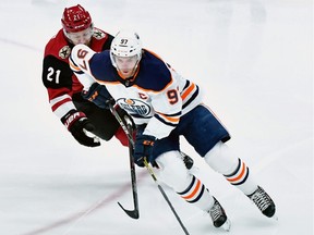 Edmonton Oilers centre Connor McDavid carries the puck against Arizona Coyotes center Derek Stepan at Gila River Arena on Tuesday, Feb. 4, 2020.