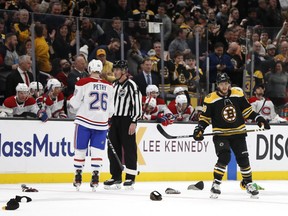 As hats litter the ice in honour of his third goal of the night, Bruins' David Pastrnak skates past Canadiens' Jeff Petry Wednesday night in Boston.