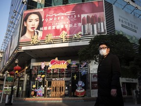 A man wears a protective mask as he walks in the Wuhan business district, Hubei province, China, on Thursday, Feb. 13, 2020.