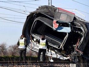 Members of Italian Police inspect the wreckage of a derailed train, outside the city of Lodi, near Milan, Italy, on Thursday, Feb. 6, 2020.