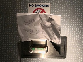 A photo of the handwritten sign saying "lavatory for crew members only" is pictured on flight KL855 from Amsterdam to Seoul, February 10, 2020 in this picture obtained by Reuters from social media on February 14, 2020. (Connie Kim via REUTERS)