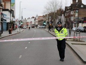 A police officer is seen near a site where a man was shot by armed officers in Streatham, south London, England, on Sunday, Feb. 2, 2020.