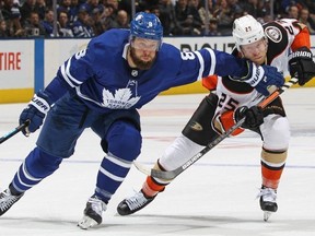Leafs defenceman Jake Muzzin (left) battles Anaheim Ducks’ Ondrej Kase at Scotiabank Arena Friday night. The Leafs won 5-4 in OT.