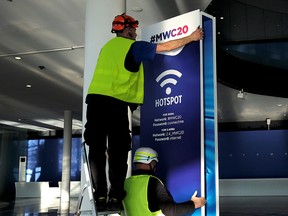 Employees place a banner with information of MWC20 (Mobile World Congress) in Barcelona, Spain Feb. 5, 2020.