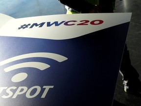 An employee walks past an MWC20 (Mobile World Congress) banner in Barcelona, Spain Feb. 5, 2020.