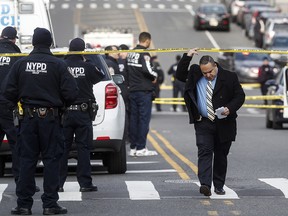 New York police officers work the scene of a shooting outside the 41st precinct Sunday, Feb. 9, 2020, in New York. (AP Photo/John Minchillo)