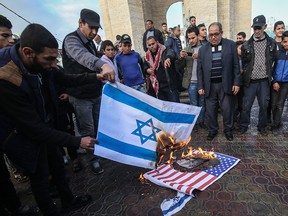 Palestinian demonstrators burn the Israeli and U.S. flags during a protest against a U.S.-brokered Middle East peace plan in Rafah in the southern Gaza Strip, on February 1, 2020. (SAID KHATIB/AFP via Getty Images)