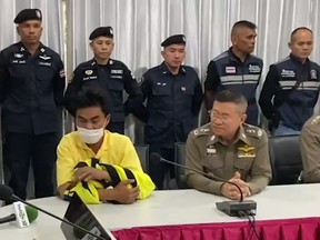 Amornrak Jitkkoh (in yellow) talks to the police and media in Thailand. (Video screen grab)