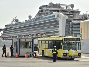 A bus carrying passengers who disembarked from the Diamond Princess cruise ship (back), in quarantine due to fears of the new COVID-19 coronavirus, leaves the Daikoku Pier Cruise Terminal in Yokohama on February 20, 2020. (KAZUHIRO NOGI/AFP via Getty Images)
