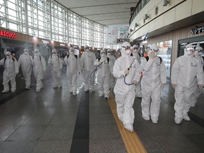 South Korean soldiers wearing protective gear sanitize Daegu railway station in Daegu, South Korea, Feb. 29, 2020.