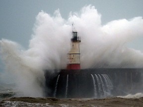 Waves crash over Newhaven Lighthouse on the south coast of England on February 9, 2020, as Storm Ciara swept over the country. (GLYN KIRK/AFP via Getty Images)