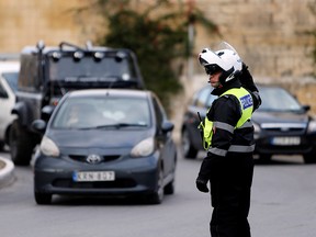 A traffic police officer directs traffic in Kappara, Malta February 5, 2014. (REUTERS/Darrin Zammit Lupi)