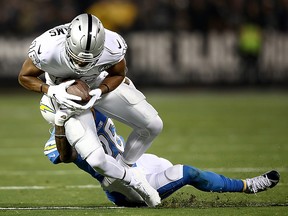 Wide receiver Tyrell Williams of the Oakland Raiders is tackled by cornerback Casey Hayward of the Los Angeles Chargers during the first quarter at RingCentral Coliseum on Nov. 7, 2019 in Oakland, Calif.