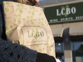 A woman carries a bag of purchased alcohol at an LCBO store in Toronto. (Ernest Doroszuk/Toronto Sun files)