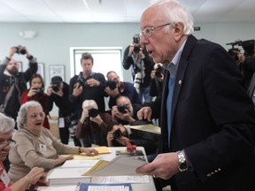 Democratic presidential candidate Sen. Bernie Sanders (I-VT) picks up a ballot from the check-in counter at a polling place March 3, 2020 at Robert Miller Community Center in Burlington, Vermont.