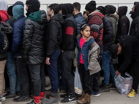 Refugees and migrants wait in line  to receive blankets and food from NGO Atles Yadim near the Edirne Old Bridge on March 5, 2020 in Edirne, Turkey.