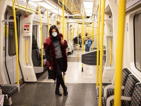 A woman wears a protective mask as she travels on an underground train on March 20, 2020 in London, England.