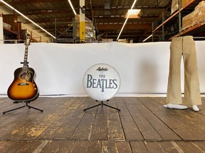 A wooden stage from the Liverpool venue where the Beatles performed before they became famous is displayed in a Julien's Auctions warehouse in Torrence, Calif., March 5, 2020, with a pair of pants worn by John Lennon, a guitar played by Paul McCartney and a bass drumhead printed with The Beatles' logo. REUTERS/Jane Ross