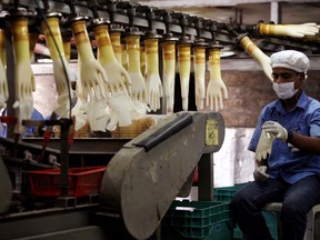 A worker monitors a production line at a Top Glove factory in Meru outside Kuala Lumpur, June 25, 2009. (REUTERS/Bazuki Muhammad/File Photo)