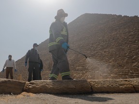 A member of the medical team sprays disinfectant as a precautionary move amid concerns over the coronavirus disease (COVID-19) outbreak at the Great Pyramids, Giza, on the outskirts of Cairo, Egypt, March 25, 2020. REUTERS/Amr Abdallah Dalsh