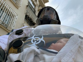 Cao Junjie poses for a picture with his two-month old baby inside a safety pod he created to protect his baby from the coronavirus disease (COVID-19), at a residential compound in Shanghai, China March 25, 2020. (REUTERS/Xihao Jiang)