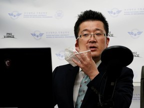 A professor of Pusan National University Park Hyun who used to be a coronavirus patient, takes off his mask as he gives an online lecture at Pusan National University in Busan, South Korea, March 30, 2020. (REUTERS/Kim Hong-Ji)