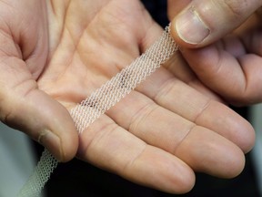 In this Dec. 20, 2018, photo, Dr. Jeffrey Clemons, a pelvic reconstructive surgeon, holds a sample of transvaginal mesh used to treat pelvic floor disorders and incontinence in women as he poses for a photo in Tacoma, Wash. (AP Photo/Ted S. Warren)