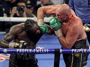 In this file photo taken on Feb. 22, 2020 British boxer Tyson Fury, right, slams a right to the head of U.S. boxer Deontay Wilder during their World Boxing Council (WBC) Heavyweight Championship Title boxing match at the MGM Grand Garden Arena in Las Vegas. (JOHN GURZINSKI/AFP via Getty Images)