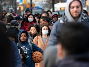 In this file photo taken on March 2, 2020 people wear face masks as they walk down a street in Flushing area of Queens in New York City.