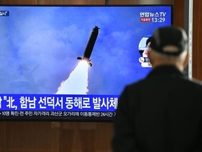 A man watches a television news broadcast showing a file image of a North Korean missile test, at a railway station in Seoul on March 9, 2020.