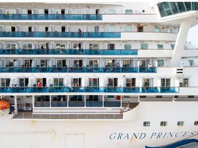 Passengers look out from the Grand Princess cruise ship at the Port of Oakland in Oakland, California on March 9, 2020.