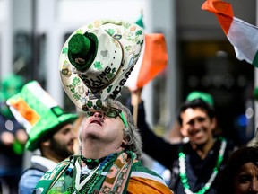 In this file photo taken on March 16, 2019 a man balances his hat during the annual New York City St. Patrick's Day Parade on March 16, 2019.