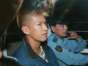 This file photo taken on July 27, 2016 shows murder suspect Satoshi Uematsu (L) sitting in the back seat of a police vehicle as he returns to the Tsukui police station in Sagamihara, Kanagawa prefecture.
